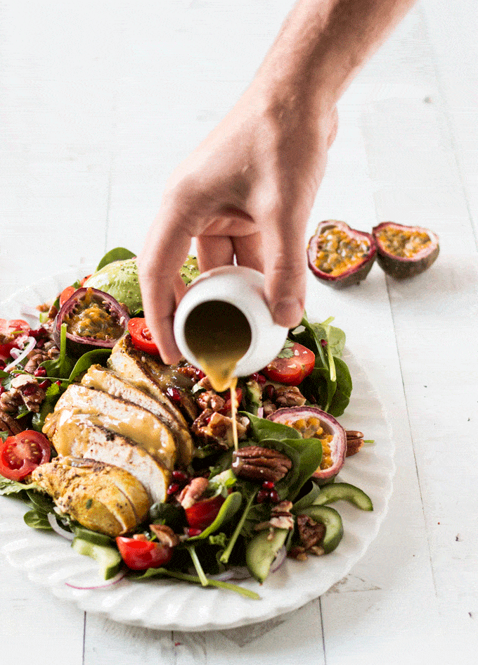 Pouring the passionfruit dressing on the chicken salad