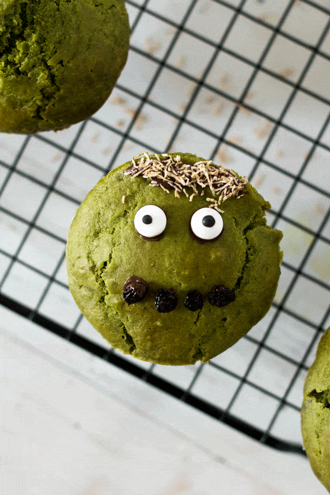 green monster muffin with googly candy eyes, a monobrow made from shredded wheat and a mouth made of currants