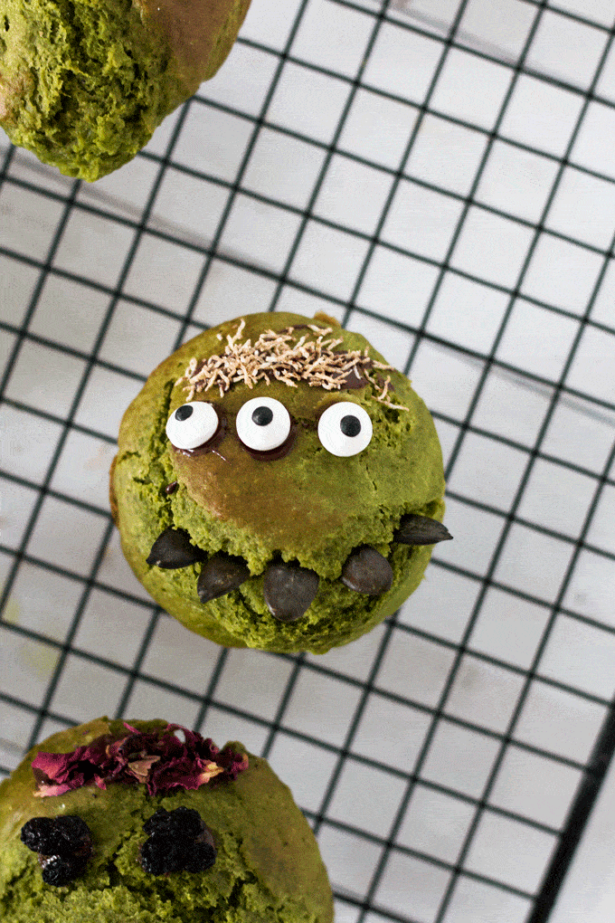 a green monster muffin with 3 candy eyes and sunflower seeds as spiky teeth