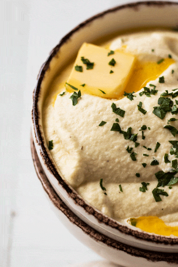 Big bowl of Roasted Parsnip Puree topped with a pat of butter and some herbs