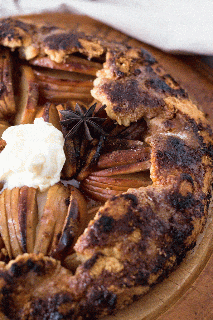 up close shot of a warm apple crostata with a dollop of ice cream on top