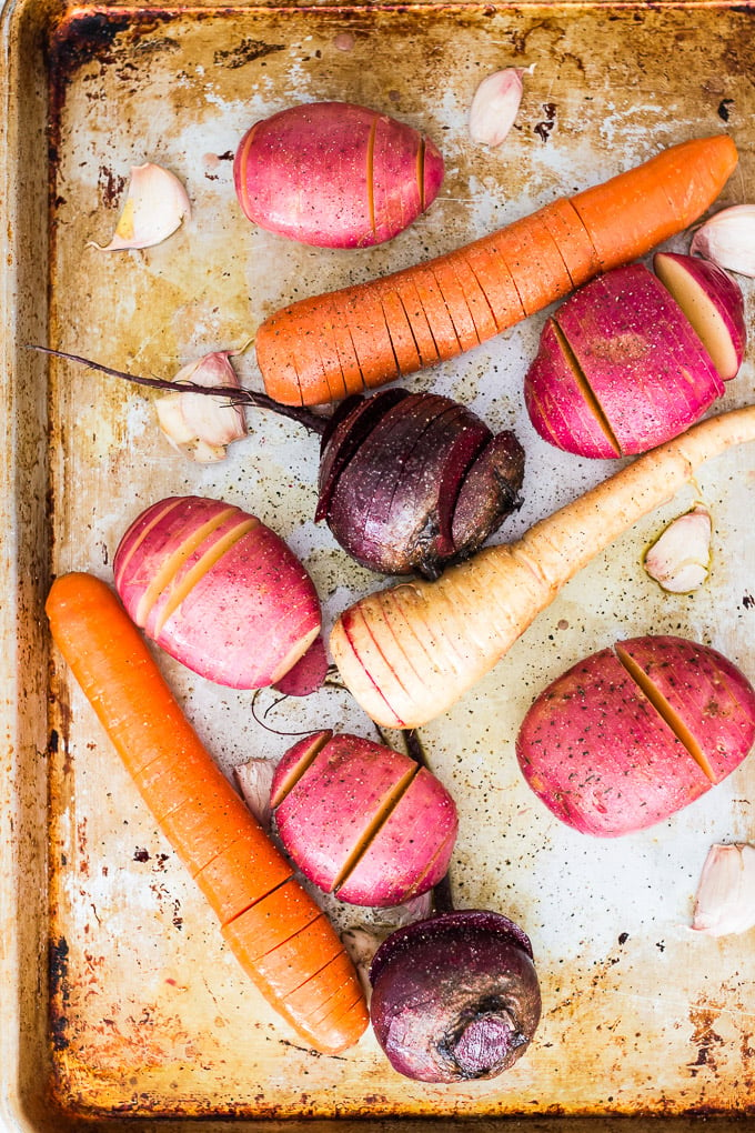 veggies spread out on a baking tray for garlic hasselback potatoes