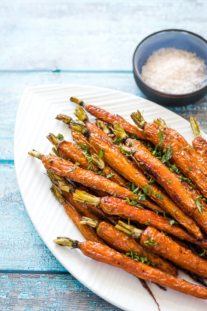 Roasted Dutch Carrots on a white platter with a side of himalayan pink salt