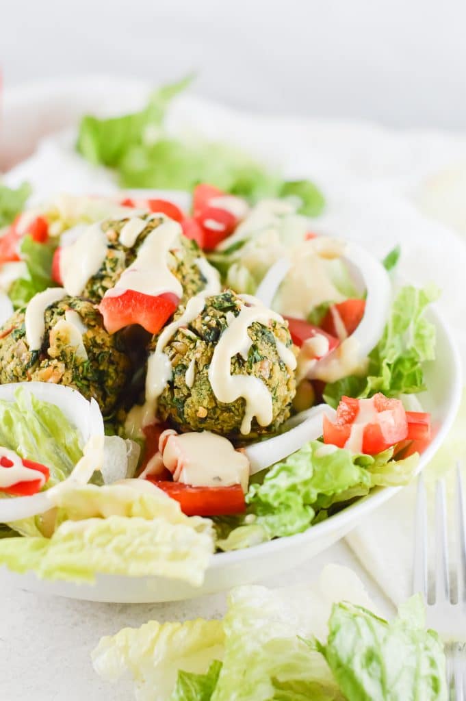 Falafel bowl with salad against a white background