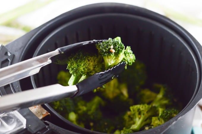 Lemon and garlic broccoli being removed from the air fryer