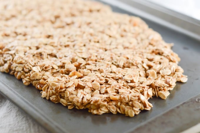 Uncooked banana granola spread on a baking tray