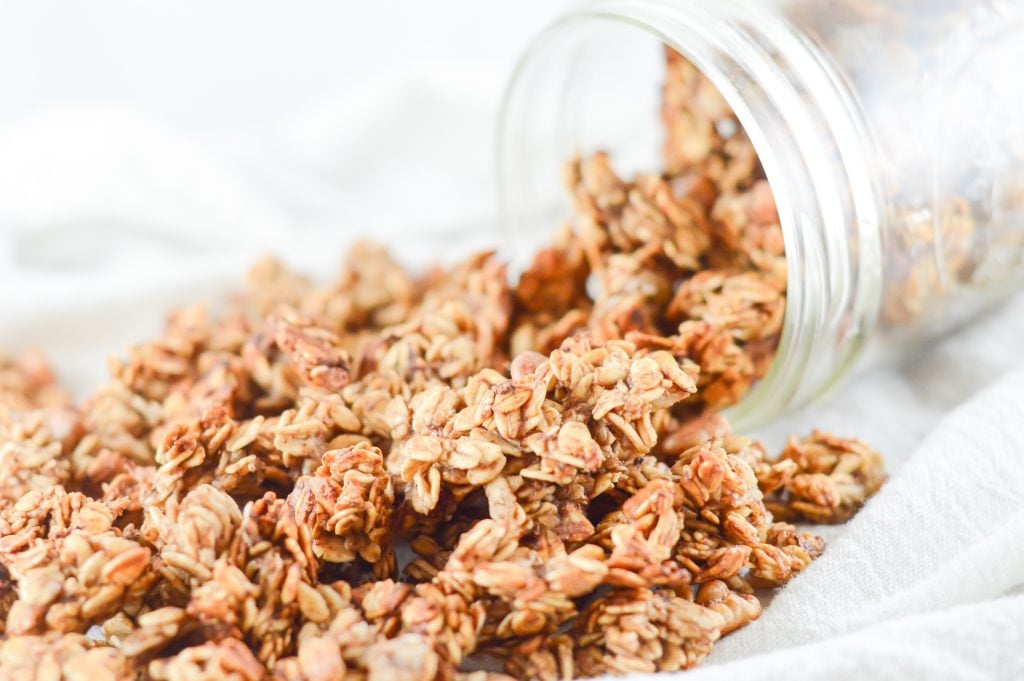 Banana bread granola spilling from a glass mason jar