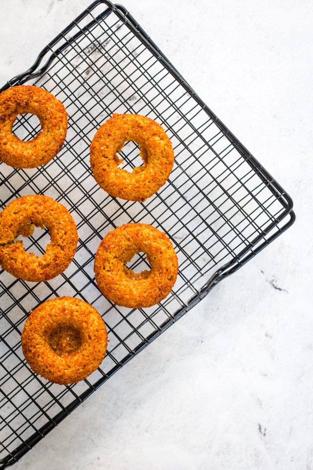 black cooling racks with freshly baked banana donuts cooling down