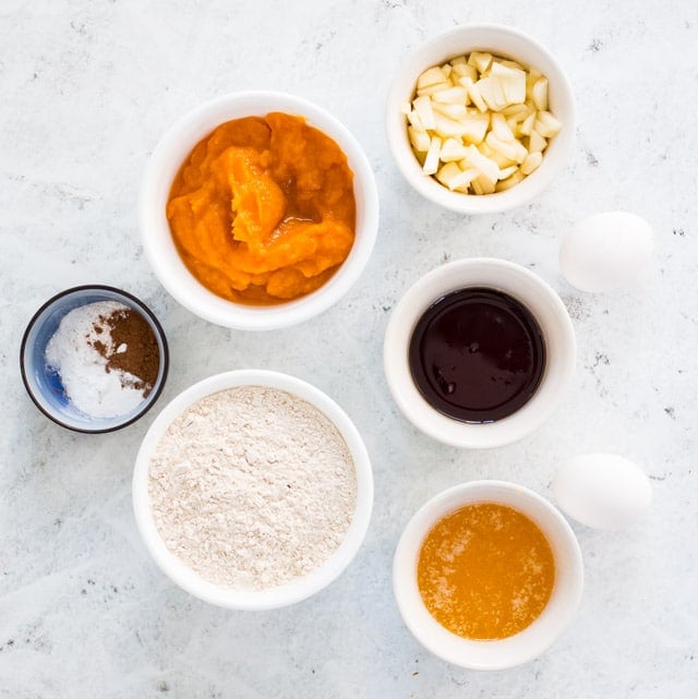 separated ingredients for healthy pumpkin bread displayed in small white bowls