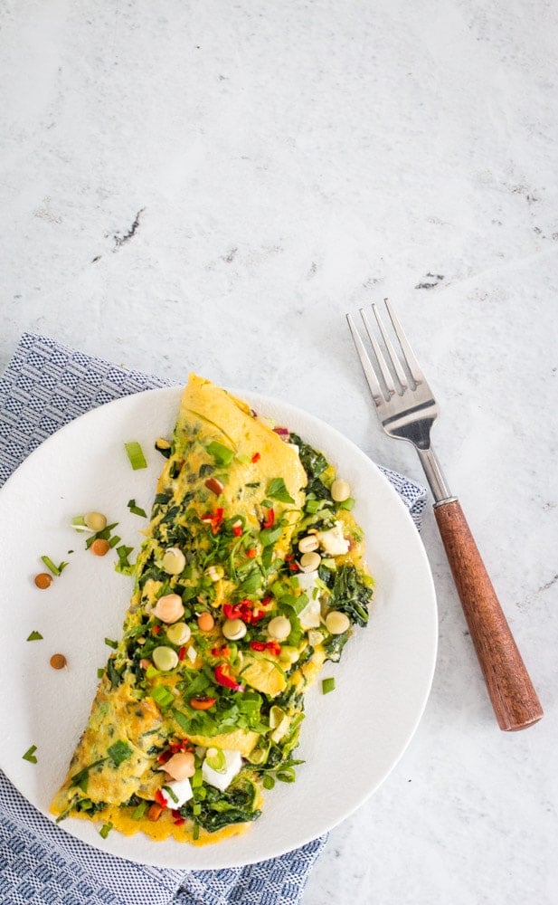 spinach and veggie omelette on a white plate