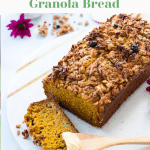 pumpkin bread topped with granola and placed on a platter plate on a white background