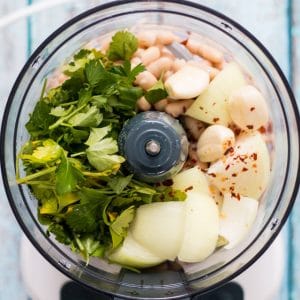 food processor with onion, garlic, beans, parsley and chili flakes