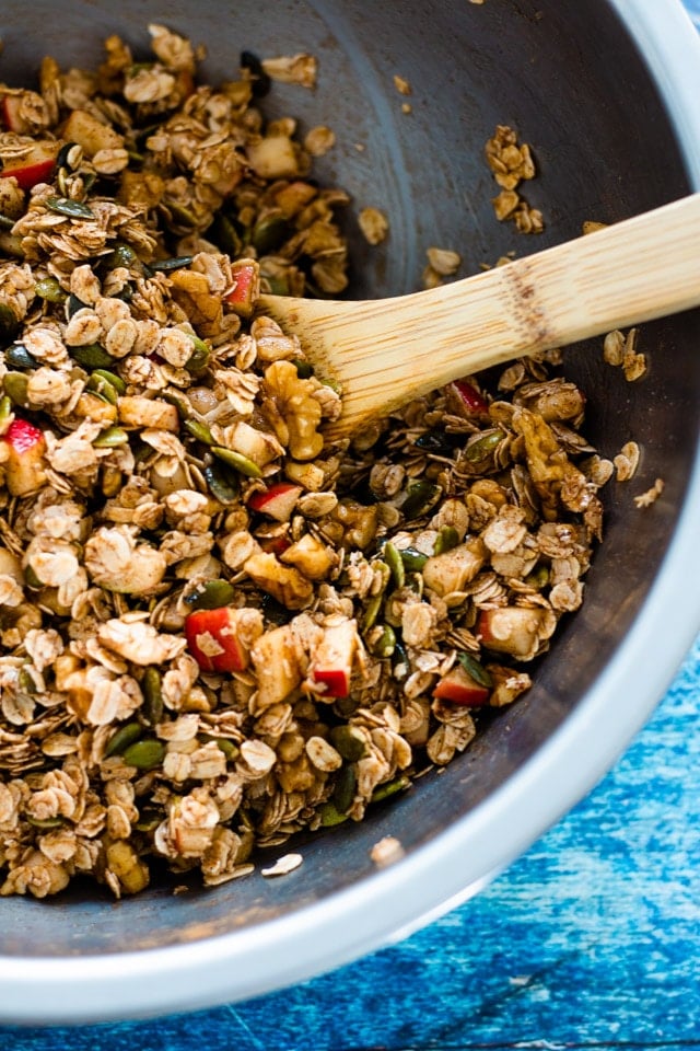 up close shot of ingredients for homemade cinnamon granola being mixed in a large stainless steel bowl