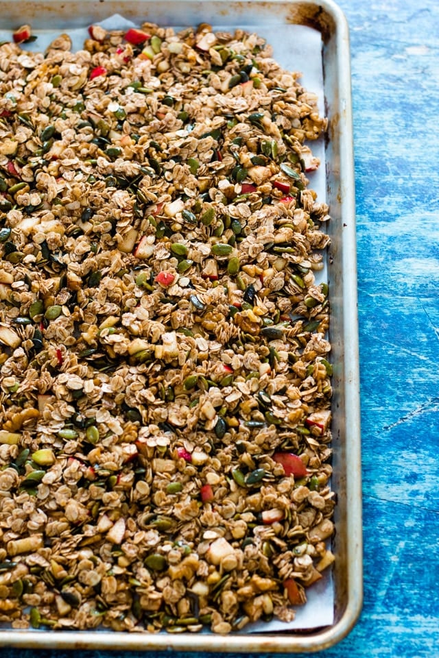 Homemade cinnamon granola spread out on a baking tray