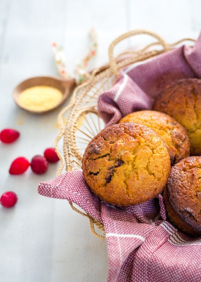 Up close shot of sweet cornbread muffins in a basket lined with red linen