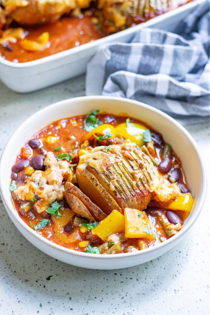 Prepared baked chili potatoes served in a white bowl