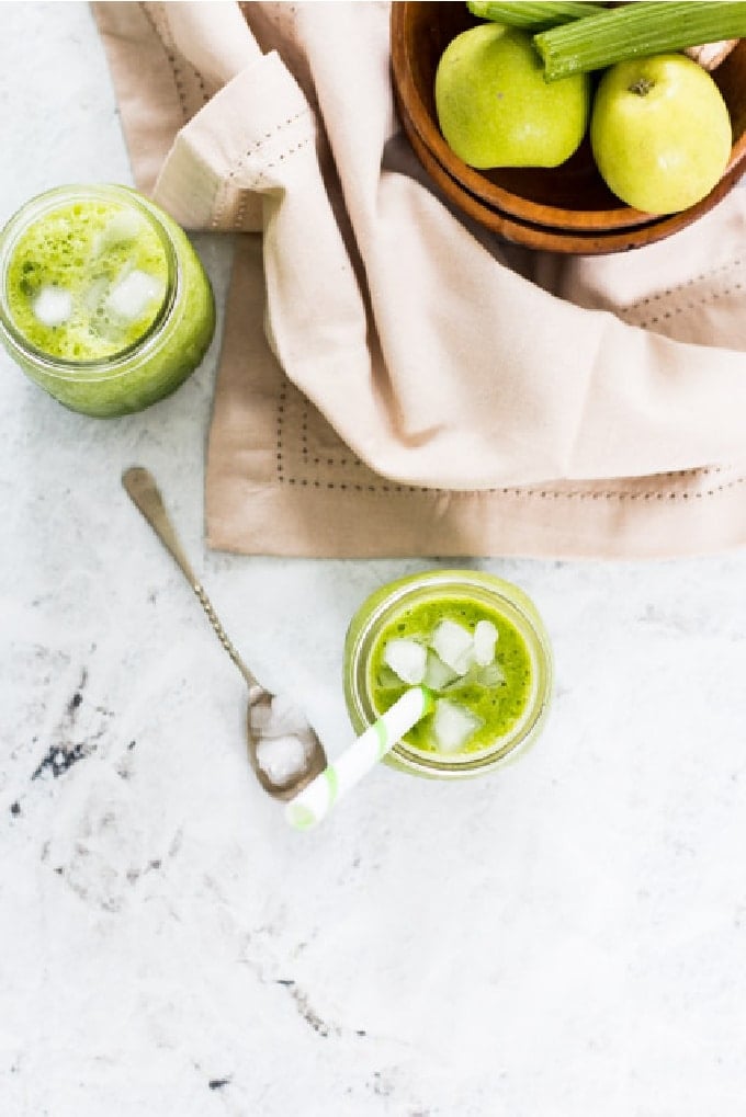 overhead shot of apple celery smoothie  in glass jars