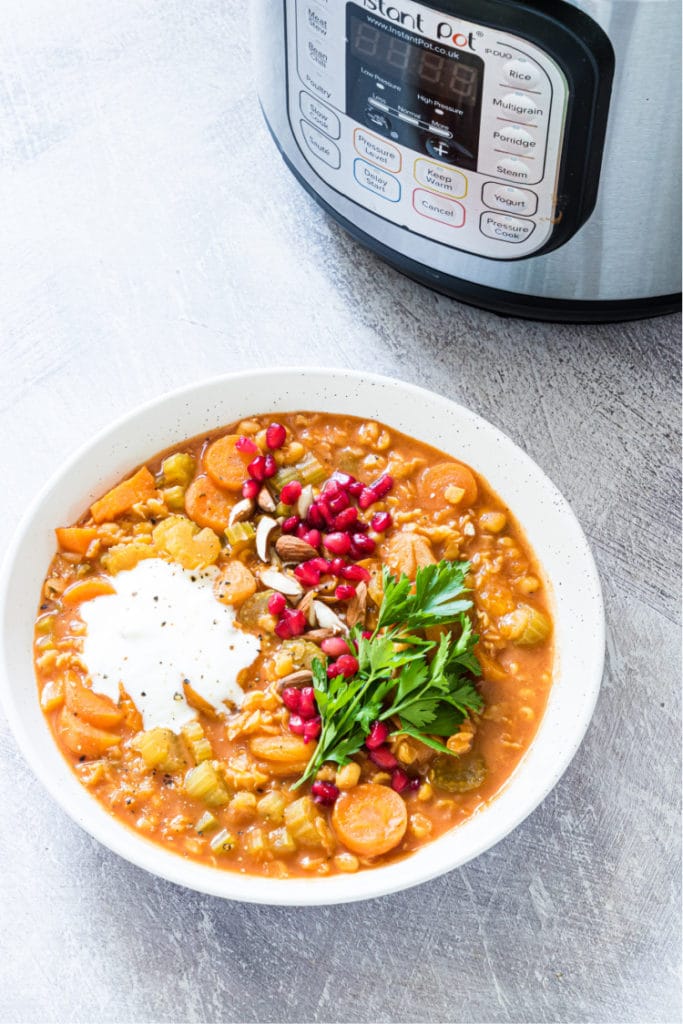 Vegan split pea soup served in a white bowl beside an instant pot