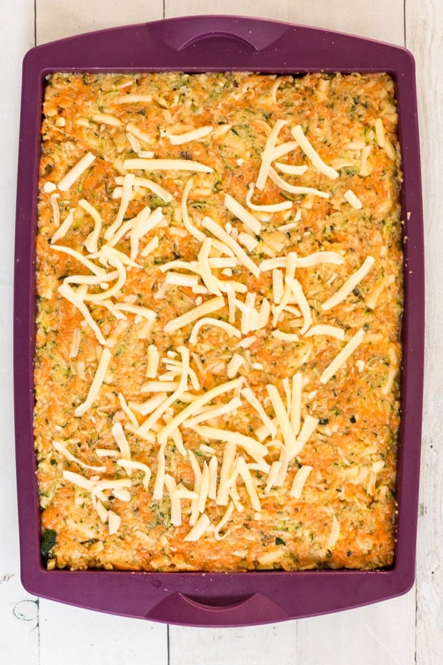 Overhead shot of a purple silicone baking pan with the uncooked ingredients of  a zucchini slice