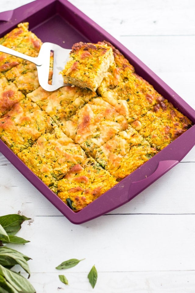 Purple silicone baking tray including a vegetable slice with a small server removing a piece