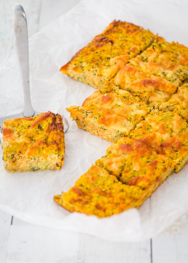 Slices of zucchini bake on parchment paper