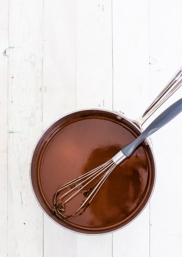 A small saucepan with a whisk whisking together the ingredients for peppermint creamer