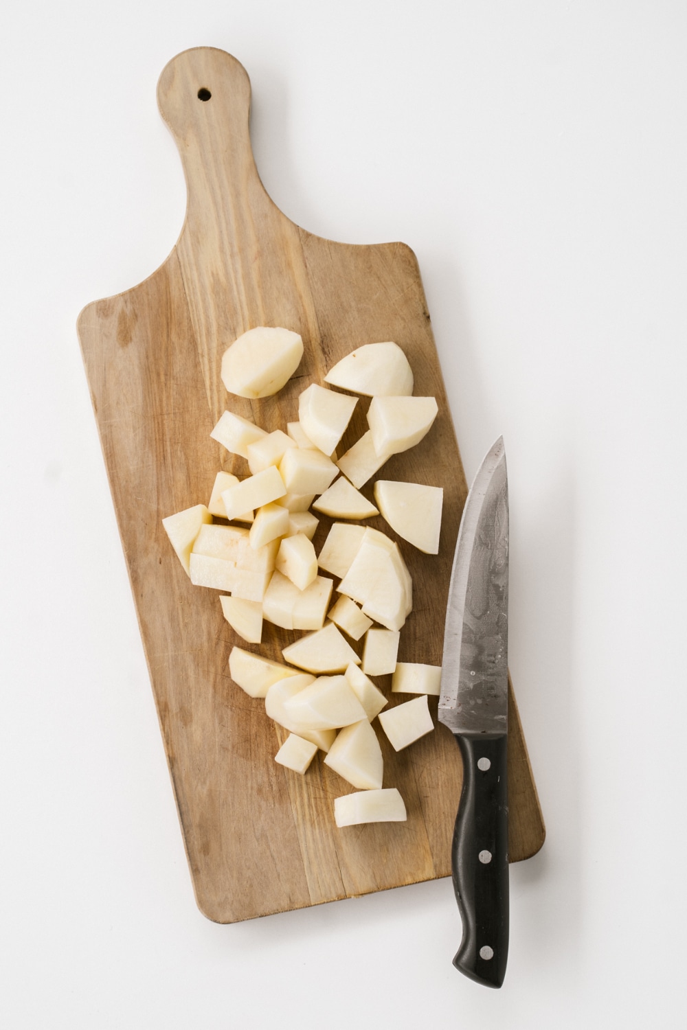 overhead flat lay shot of chopped potatoes on a wooden board