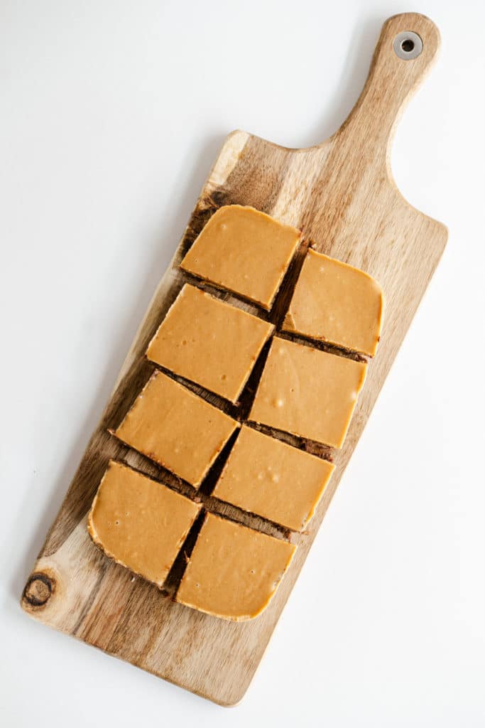 overhead shot of a caramel topped brownie in a wooden chopping board