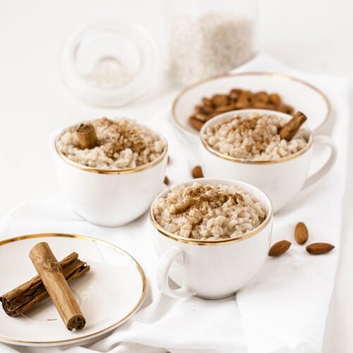 Almond milk rice pudding served in white and gold teacups