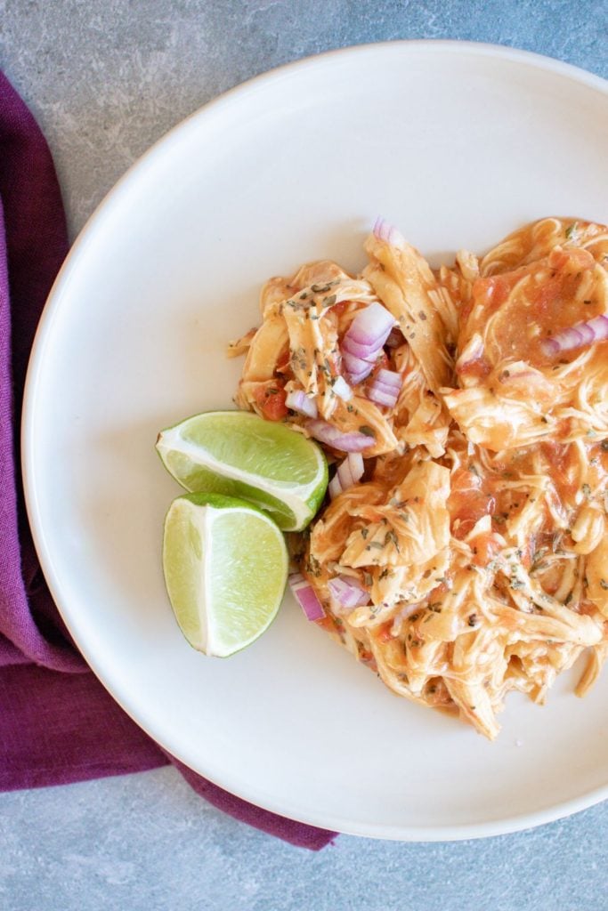 Thai inspired Instant pot chicken breasts served up on a white plate with some lime wedges