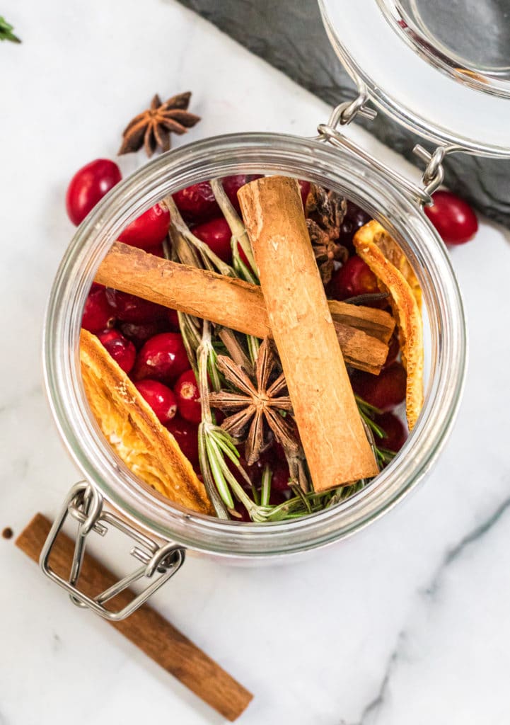 Overhead shot of a glass jar containing homemade potpourri and dried orange slices