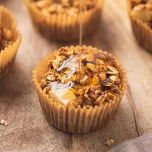 Maple syrup being drizzled on apple cinnamon oatmeal cups