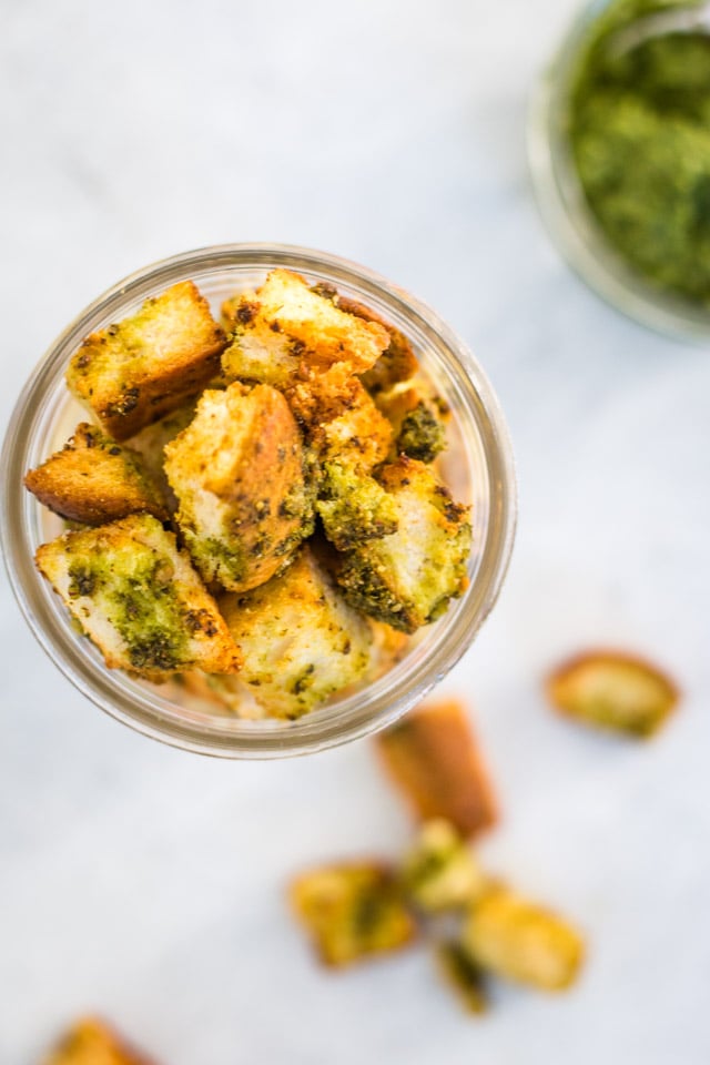 Up close overhead shot of crunchy homemade croutons stored in a glass jar