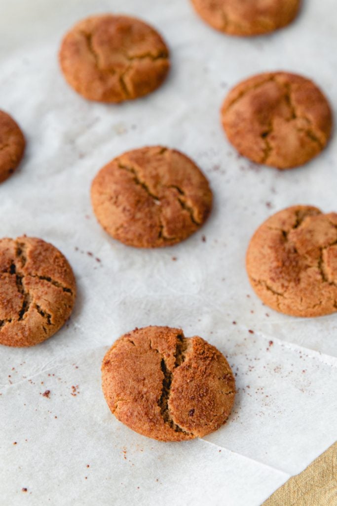 Crinkly fresh baked gingersnap cookies on a piece of parchment paper