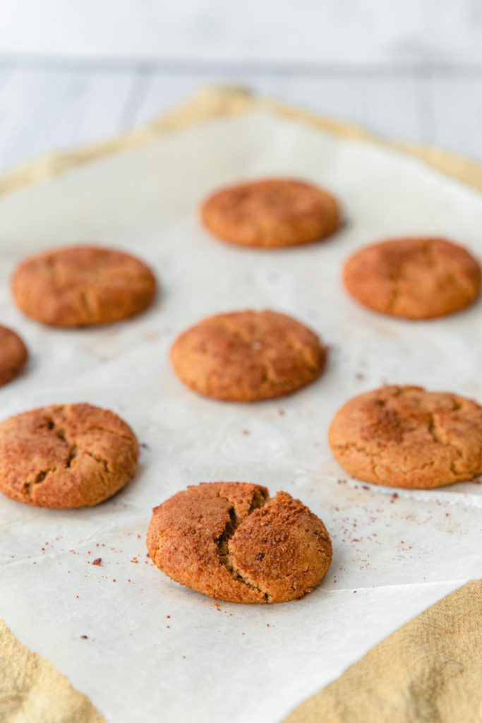 Baked gingersnap cookies on a piece of parchment paper