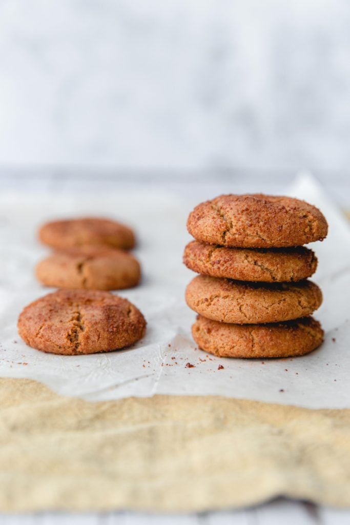 A stack of gingersnap cookies on a piece of baking paper