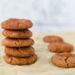A stack of baked ginger cookies on a piece of parchment paper