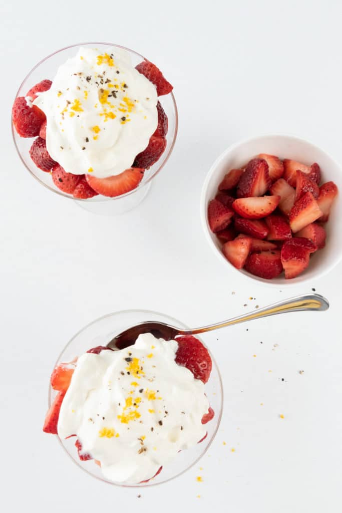 orange macerated strawberries served with whipped cream