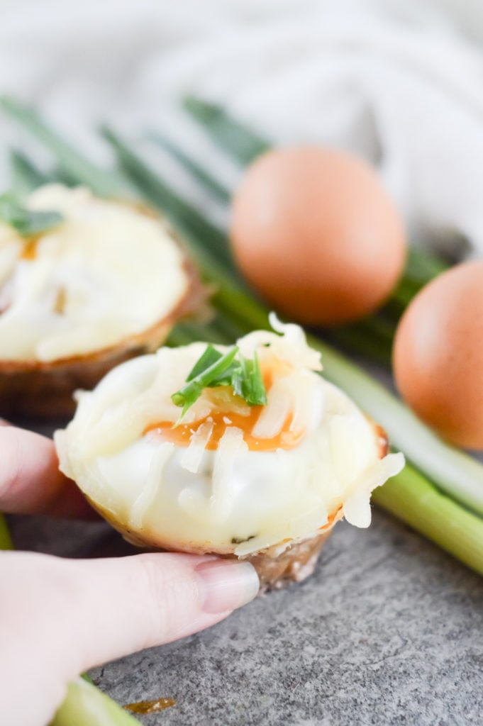 Hand grabbing Pork Sausage and Egg Muffin Cups