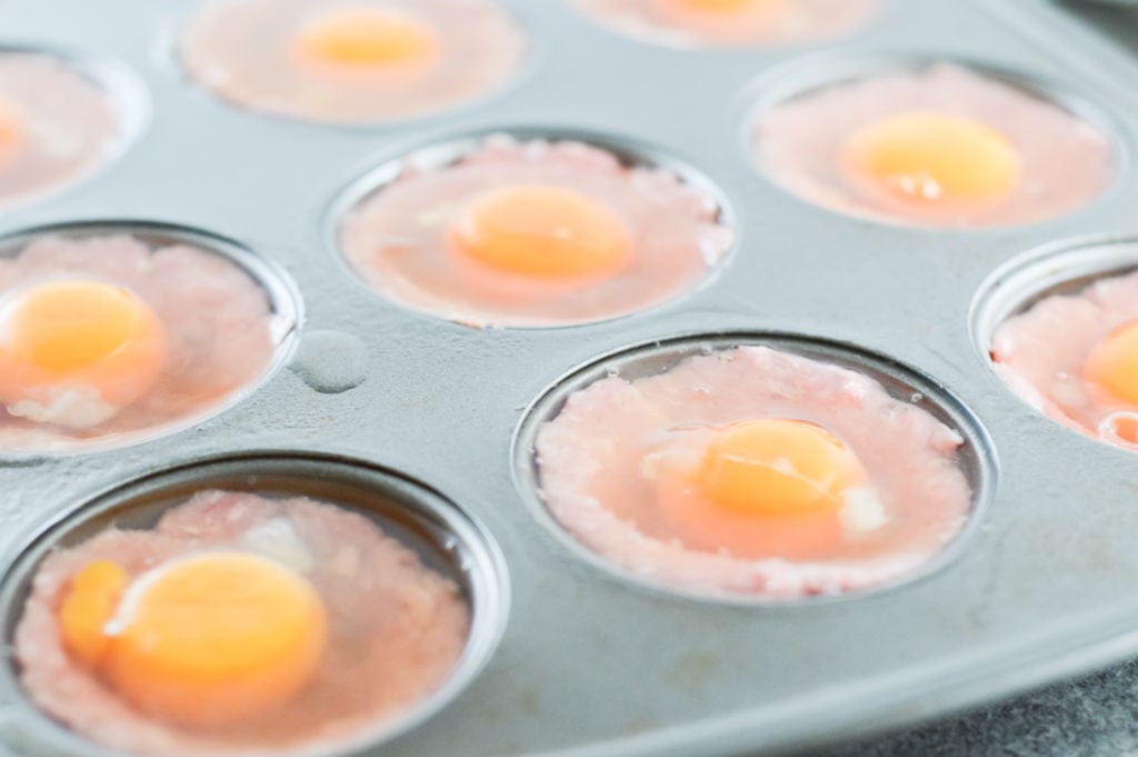 Partially cooked pork muffin cups with the egg yolk and egg white added separately to prevent overspill