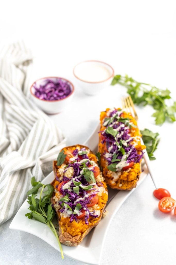 Overhead shot of cabbage and quinoa stuffed baked sweet potato served in a white plate