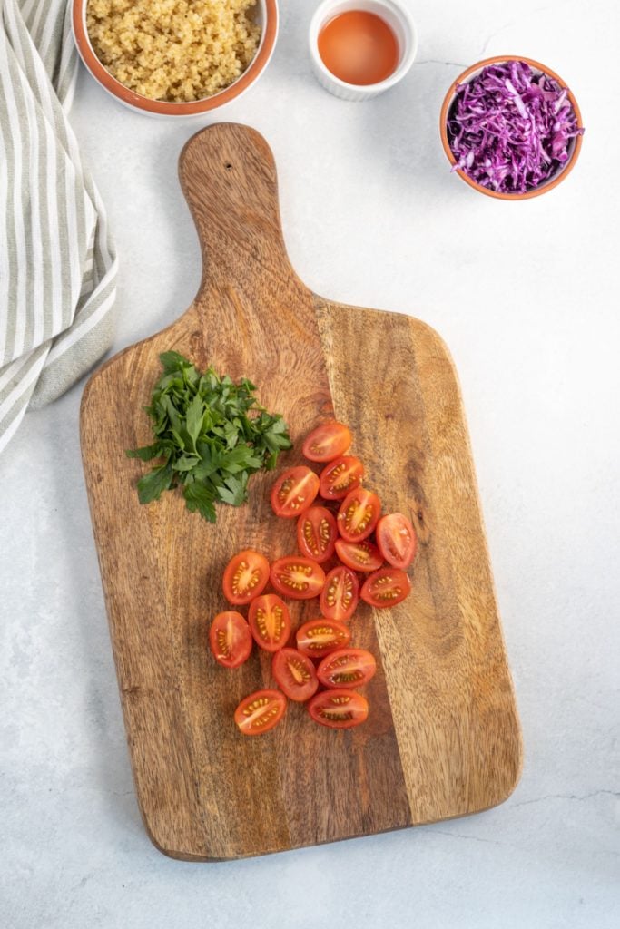 Chopped tomatoes, parsley and red cabbage served up in individual bowls for a serve-yourself baked sweet potato