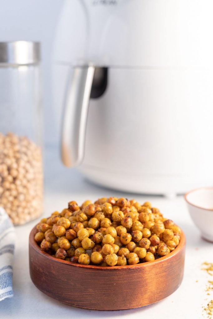 zaatar chickpeas served in a wooden bowl with a white air fryer in the background