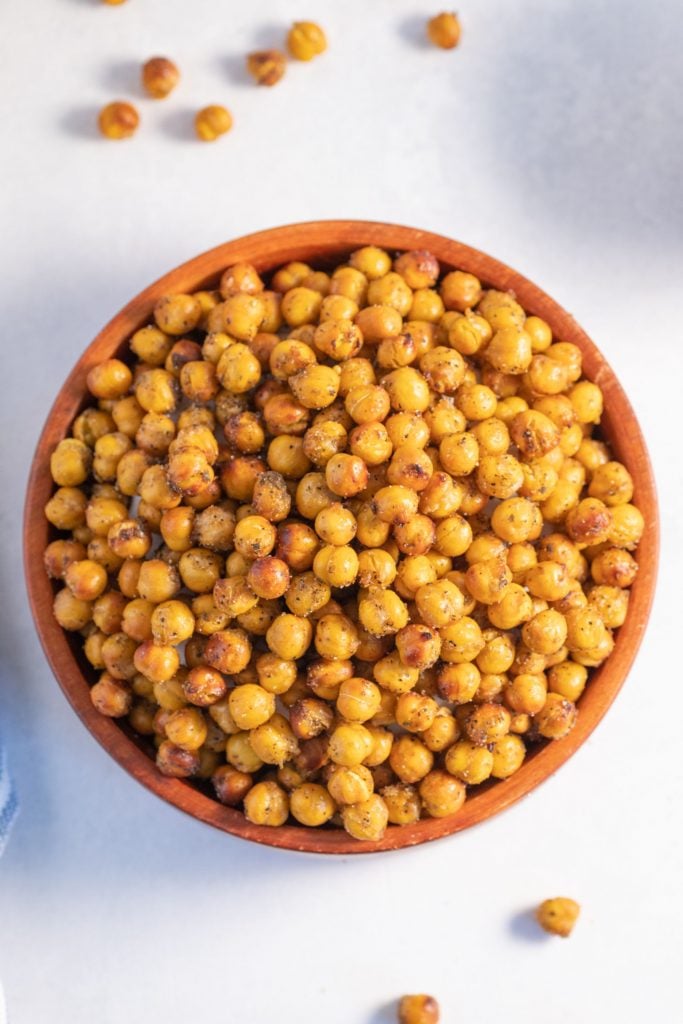 overhead shot of air fryer chickpeas coated in zaatar served in a wooden bowl against a white background