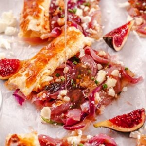 a slice of caramelized red onion tart with honey being poured on top