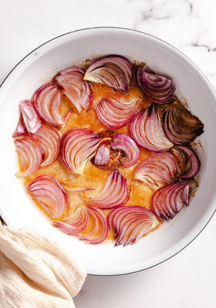 red onions being caramelized in a large pan