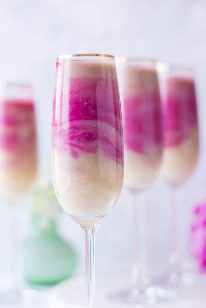Frontal view of 4 pink and white ombre smoothies served in tall skinny glasses