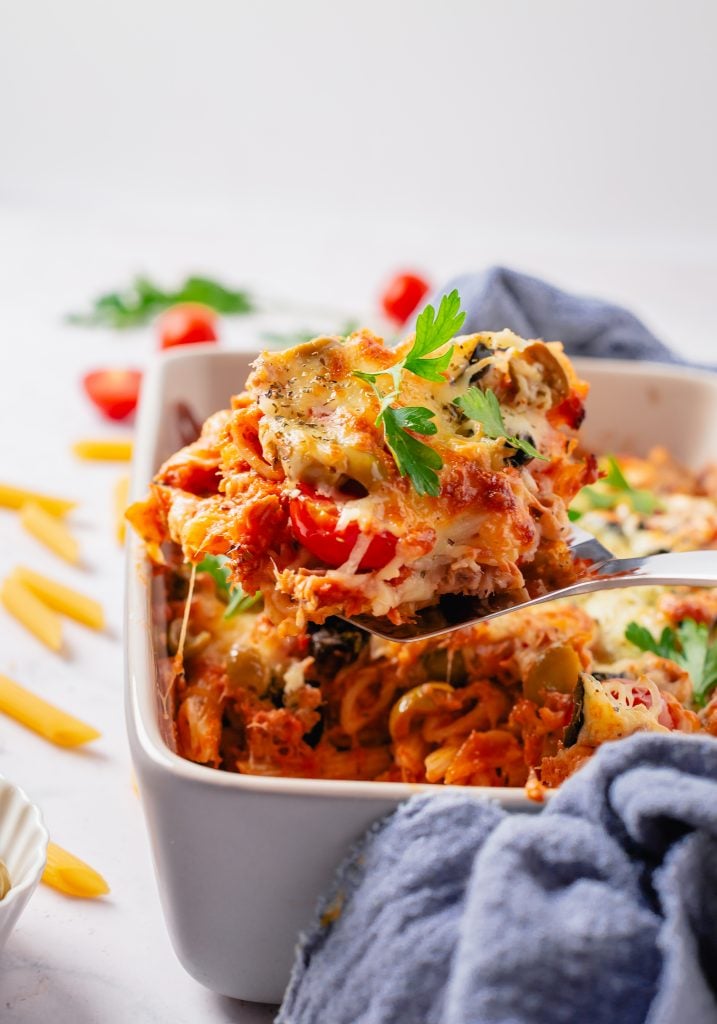 A spoonful of cooked tuna pasta being scooped out of the casserole dish.