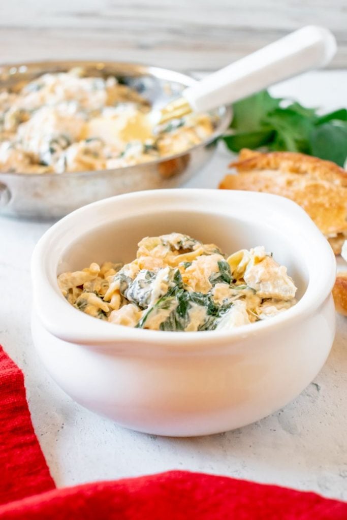 Individual serving of spinach artichoke dip served in small white bowls