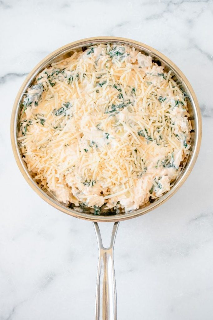 a creamy dip added to a saucepan and topped with grated cheese